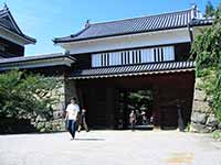 【写真・サムネイル】 上田城の本丸入り口（東虎口櫓門）。掘りに架けられた橋の向こう側に石垣に囲まれた木造の大型の門が設置されている。