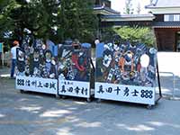 【写真・サムネイル】 上田城入り口にある顔ハメパネルの写真。真田十勇士と書かれ、10人分の顔を入れるスペースがある。